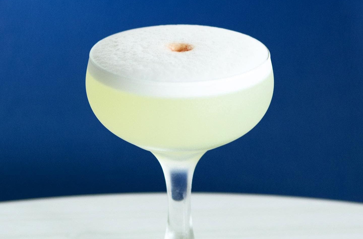 A Pisco Sour cocktail served in a coupe glass.